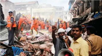  ?? AP ?? Rescue workers at the site of a building collapse in Mumbai search for survivors