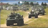  ?? The Associated Press ?? GLOBAL ROLES: Russian armored personnel carriers roll during the military exercises in the Chita region, Eastern Siberia, during the Vostok 2018 exercises in Russia on Tuesday. Russia's military chief of staff says that the military exercises expected to be the biggest in three decades, will involve nearly 300,000 troops.