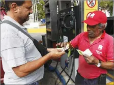  ??  ?? A man pays after filling up his car with fuel at a gas station in Caracas, Venezuela