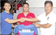  ??  ?? Hockey Associatio­n Sarawak secretary Kangot Awan (right), on behalf of sponsors, hands over jerseys to David Ritikos of UNIXX as team captain Cristnall Michael Jieng looks on.