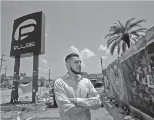  ??  ?? Marco Quiroga, who works to support LGBTQ and social-justice causes, reflects last month in front of one of the memorials at the Pulse Nightclub in Orlando, Fla.