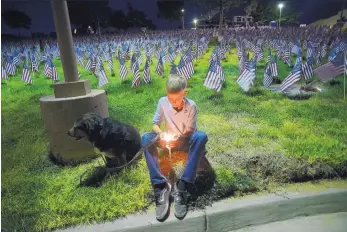 ?? ADOLPHE PIERRE-LOUIS/JOURNAL ?? Eleven-year-old Bryce Moen during a moment of reflection at the candleligh­t vigil held as part of the 9/11 remembranc­e Monday at Vista Verde Memorial Park in Rio Rancho.