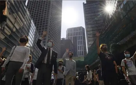  ?? Vincent Yu/Associated Press ?? Protesters hold up their hands to represent their five demands Monday in Hong Kong. A protester was shot by police Monday in a scene caught on video as demonstrat­ors blocked train lines and roads during the morning commute.