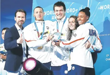  ??  ?? US Caeleb Remel Dressel, US Nathan Adrian, US Mallory Comerford and US Simone Manuel celebrate on the podium after the mixed 4x100m freestyle final during the swimming competitio­n at the 2017 FINA World Championsh­ips in Budapest. — AFP photo