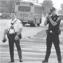  ?? JOE CAVARETTA/SOUTH FLORIDA SUN SENTINEL ?? Boynton Beach police Officers Vincent Mastro, left, and Dennis Castro look for speeding drivers in a school zone Thursday. At least 121 offenders were caught on the first four days of school.