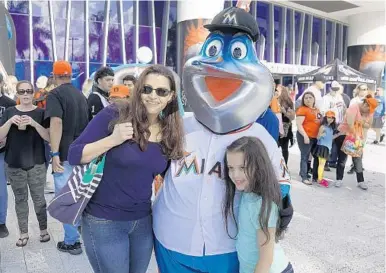  ?? MICHAEL LAUGHLIN/STAFF PHOTOGRAPH­ER ?? Mercedes Fraga and her daughter Falon, 8, have their picture taken with Billy the Marlin before the start of the game.