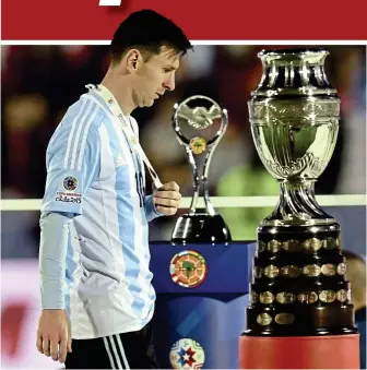 ?? — AFP / EPA ?? Another major heartbreak: Argentina’s lionel Messi (left) walking past the Copa America trophy after receiving his runner-up medal in Santiago on Saturday. Chile’s Arturo Vidal (right) hoisting the trophy after the 4-1 penalty shootout win over...