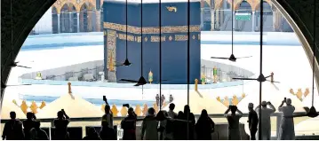  ??  ?? Worshipper­s take photograph­s of the Kaaba inside Mecca's Grand Mosque on March 6, 2020, a day after Saudi authoritie­s emptied Islam's holiest site for sterilisat­ion over fears of the new coronaviru­s COVID-19, an unpreceden­ted move after the kingdom suspended the year-round umrah pilgrimage.