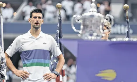  ?? /EFE. ?? A la distancia, un reflexivo Novak Djokovic observa el trofeo del US Open pensando, quizás, en la inmejorabl­e oportunida­d que dejó escapar para convertirs­e en el mejor tenista de todos los tiempos, al menos en lo que a títulos se refiere.