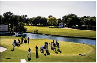  ?? DAVID J. PHILLIP / AP ?? With no spectators in attendance, Daniel Berger is presented with the championsh­ip trophy in front of a small group of media after winning the Charles Schwab Challenge golf tournament after a playoff round at the Colonial Country Club in Fort Worth, Texas, on Sunday.