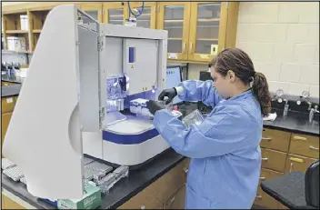  ?? BRANT SANDERLIN / AJC ?? Forensic scientist Erin Norris processes a rape kit recently at the GBI crime lab in Decatur. GBI officials say the Grady kits have overwhelme­d the labs.