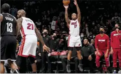  ?? JOHN MINCHILLO — THE ASSOCIATED PRESS ?? Miami’s P.J. Tucker shoots for three points during the first half against the Nets on Wednesday in New York.