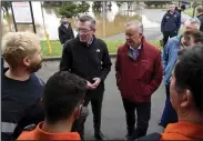  ?? (AP/AAP Image/Bianca de Marchi) ?? Australian Prime Minister Anthony Albanese (center right) and New South Wales Premier Dominic Perrottet (center left) meet flood affected locals Wednesday in Windsor on the outskirts of Sydney, Australia.