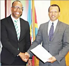  ?? (Courtesy pic) ?? EEC Managing Director Ernest Mkhonta (R) and Ubombo Sugar Limited Managing Director Muzi Siyaya shake hands after the co-generation contract signing at the EEC Head Office, Eluvatsini House.