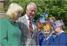  ?? ?? The King and Queen meet eight-year-old schoolchil­dren Camilla Nowawakows­ka and Charles Murray.