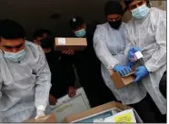  ?? (AP/Adel Hana) ?? Medics and police officers check a shipment of the Russian Sputnik V vaccine Wednesday inside a truck at the Kerem Shalom border crossing in Rafah, Gaza Strip.