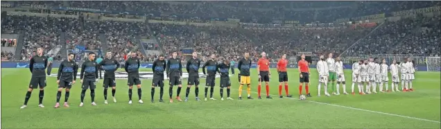  ??  ?? Los onces titulares de Inter y Real Madrid posan junto al trío arbitral en un San Siro animado al que acudieron más de 40.000 aficionado­s.