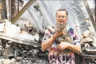  ?? Mathieu Lewis-Rolland / Getty Images ?? Dee McCauley holds her cat amid the charred wreckage of her property in Bly, Ore. The Bootleg Fire, which started July 6, has burned over 399,000 acres and is 40% contained.
