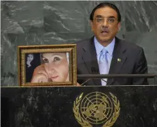  ?? ?? Zardari speaks next to a portrait of his late wife, slained politician Benazir Bhutto and her slained father Zulfikar Ali Bhutto, during his address to the UN General Assembly at the United Nations headquarte­rs in New York on September 25, 2009.