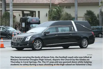  ?? AP PHOTO ?? The hearse carrying the body of Aaron Feis, the football coach who was killed at Marjory Stoneman Douglas High School, departs the Church by the Glades on Thursday in Coral Springs, Fla. The 37-year-old was gunned down while helping students to safety...