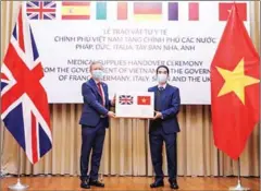  ??  ?? Vietnamese deputy foreign minister To Anh Dung (right) presents 100,000 face masks as a donation from Vietnam to the UK Ambassador to Vietnam Gareth Ward.