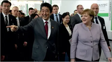  ??  ?? ABOVE German chancellor Angela Merkel and Japanese prime minister Shinzō Abe walk the floor