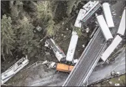  ?? BETTINA HANSEN/SEATTLE TIMES FILE PHOTOGRAPH ?? Emergency crews respond after an Amtrak train derailed and fell off of a bridge and onto Interstate 5 near Mounts Road between Lakewood and Olympia, Wash., on Dec. 18.