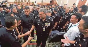  ??  ?? KHALID (tengah) bersalam dengan pegawai polis di Dewan Utama IPK Kedah, semalam.