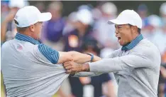  ??  ?? SALVATION: Justin Thomas rejoices with Tiger Woods after snatching a win on the last hole.
