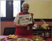  ?? KEVIN MARTIN — THE MORNING JOURNAL ?? Lorain Historical Society volunteer Carm Januzzi holds up the 2018 calendar “In the Hands of Women” featuring the work of artist Peggy Ascensio at the annual holiday gift shop open house on Nov. 12. Januzzi’s hands are featured in the calendar along...