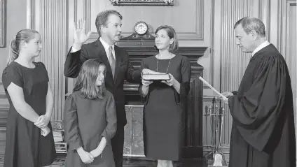  ?? Fred Schilling / Collection of the Supreme Court via AP ?? Chief Justice John Roberts administer­s the oath to Brett Kavanaugh in the Justices’ Conference Room inside the Supreme Court Building on Saturday. Kavanaugh’s wife, Ashley, holds the Bible as their daughters Margaret, left, and Liza watch.