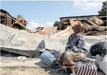  ?? ?? A LOCAL resident sits near the remains of a destroyed bank in Palma, Cabo Delgado province, last month. In March last year, Islamic State fighters attacked the port city – the jewel in the crown of Mozambique’s gas project that would supposedly shower the province with quality jobs and desperatel­y-needed infrastruc­ture. | AFP