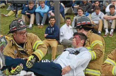  ?? PETE BANNAN – DIGITAL FIRST MEDIA ?? Malvern Fire Company removes a victim (J.R. Bryne of Malvern Prep) during a mock car accident at Villa Maria Academy Thursday morning.