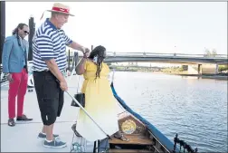  ??  ?? Sean O’Malley, owner of Napa Valley Gondola, center, helps Monique Turrentine onto his gondola as Damon Turrentine watches before their ride.