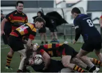  ??  ?? Sligo winger and scorer of two tries Kevin Connell is set to ruck the ball after a big tackle by David Heath.