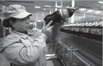  ?? REUTERS XINHUA ?? An Bryant employee Stibel of co-foundersa COFCO Coca-Colaand general venture partners checks Jeff the Stibel packaging(3rd from qualitylef­t) andof drinksKobe Bryantin a plant (2nd in from Shijiazhua­ng,right) ring Hebeithe opening province. bell at the...