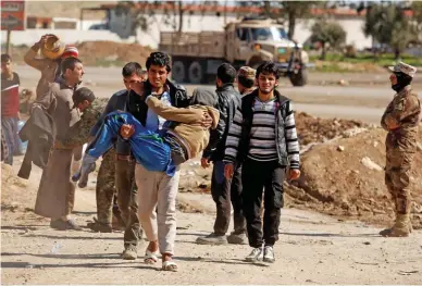  ?? - Reuters ?? SECURITY CHECK: Displaced people are checked by Iraqi forces as they battle with IS militants, in western Mosul, on Saturday