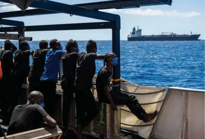  ?? © ?? Vanop een Duits ngo-schip kijken migranten naar de Maersk Etienne, een Deense olietanker met 27 migranten die al een maand wacht op toegang tot een Maltese haven.
Thomas Lohnas, afp