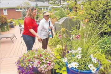  ?? SUE ELLEN ROSS/POST-TRIBUNE PHOTOS ?? Joyce Leavitt, left, of Ogden Dunes, and her daughter Amy Walter, of Dyer, admire flowers in one of the gardens along the Miller Garden Club’s Secret Garden walking tour.