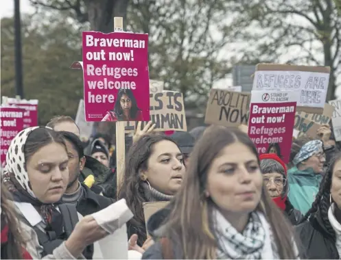  ?? ?? ↑ Demonstrat­ors hold placards as they take part to a protest outside the Manston immigratio­n short-term holding facility near Thanet