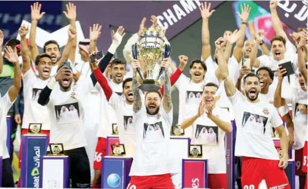  ??  ?? ↑
Shabab Al Ahli’s jubilant players pose with the winners’ trophy after being crowned champions of the current edition of the Arabian Gulf Super Cup.