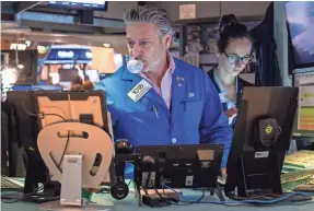  ?? SPENCER PLATT/GETTY IMAGES ?? Traders work on the floor of the New York Stock Exchange (NYSE) on April 10. Some analysts believe Thursday's weaker-than-expected report signals the start of a broader slowdown in the economy.