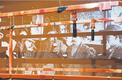  ?? Photos by Daniel Brenner, Special to The Denver Post ?? A projection of beer drinkers from the 1800s behind a scissor lift at the “Beer Here!” exhibit.