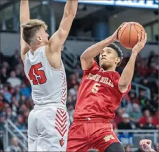  ?? JJ LaBella/For the Post-Gazette ?? Penn Hills’ Robert Thomas, right, works for a shot against Peters Township’s Jack Dunbar Thursday night.