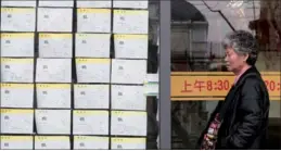  ?? GAO ZHENG / FOR CHINA DAILY ?? A citizen checks house leasing informatio­n on Xiangyang Road, Shanghai.