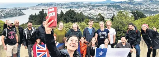  ?? PHOTO: PETER MCINTOSH ?? The big picture . . . University of Canterbury School of Forestry student Paula Yarur, formerly of Santiago, Chile, takes a selfie with fellow Winds of Change leadership group members at the Signal Hill monument in Dunedin yesterday.