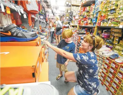  ?? STAFF PHOTO BY TIM BARBER ?? Susan Waskey looks for back-to-school shoes with her son, Nate, 6, Thursday at Sear’s Shoe Store in Fort Oglethorpe.