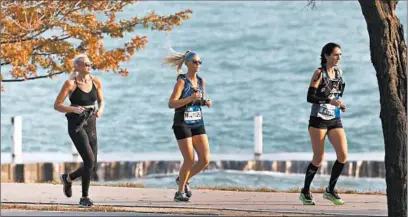  ?? ANTONIO PEREZ/CHICAGO TRIBUNE ?? A few runners take part in their own marathons near 31st Street Beach in Chicago on Oct. 11.