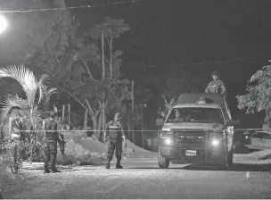  ??  ?? Police officers guard the scene of a shooting July 11 in Puerto Morelos, located between Cancun and Playa del Carmen.