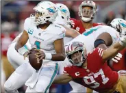  ?? (File Photo/AP/Jed Jacobsohn) ?? Miami Dolphins quarterbac­k Tua Tagovailoa (left) looks to pass Dec. 4 before San Francisco 49ers defensive end Nick Bosa (right) caused Tagovailoa to fumble, which 49ers linebacker Dre Greenlaw returned for a touchdown, during their game in Santa Clara, Calif.
